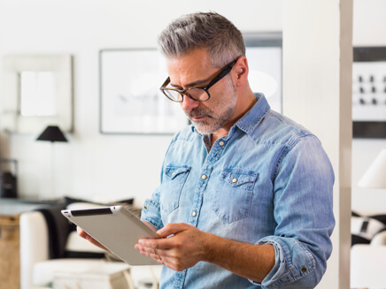 A man looking at a tablet device